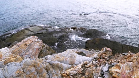 paisaje escénico en cámara lenta de la costa de la ola del mar de la naturaleza a la playa con piedra y roca para el concepto de vacaciones de verano