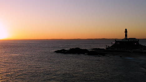 Vista-Aérea-Del-Farol-Da-Barra-Iluminada-Por-El-Sol,-El-Barrio-Alrededor-Y-El-Mar,-Al-Atardecer,-Salvador,-Bahia,-Brasil