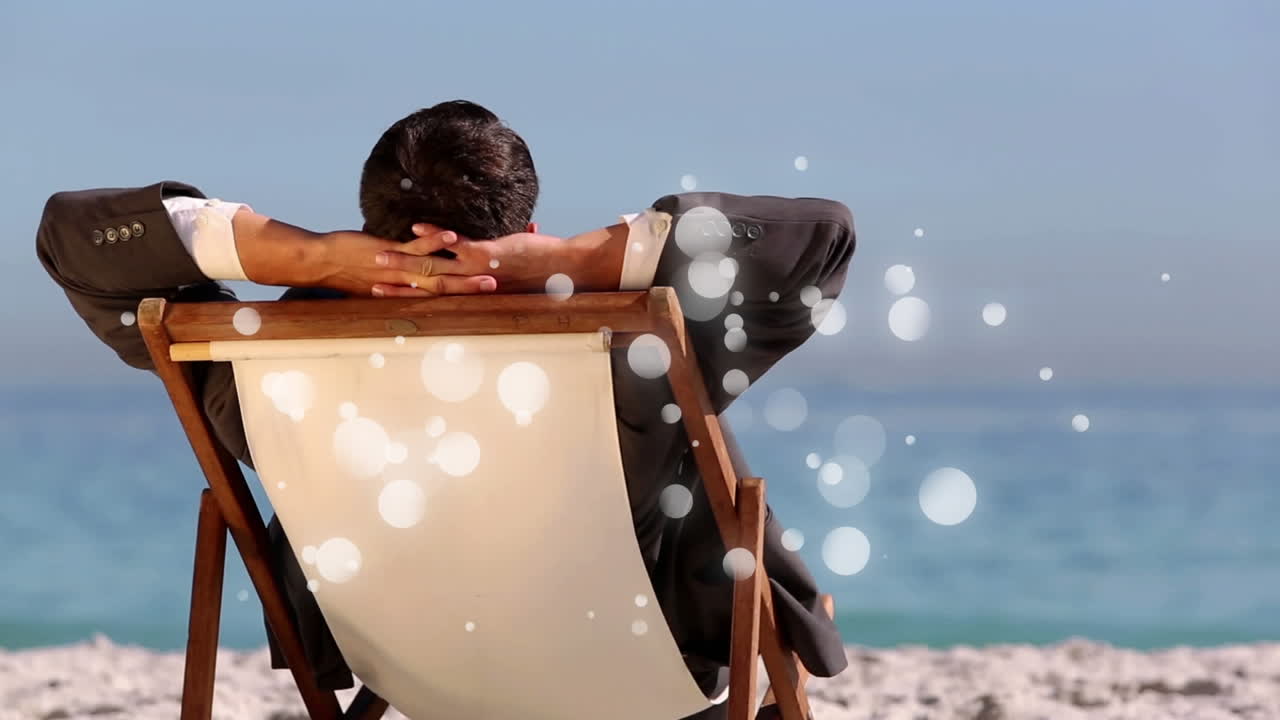 거품 빛 애니메이션과 함께 바다 앞의 갑판 의자에 앉아있는 백인 남자