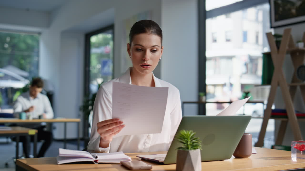 Frustrated businesswoman analyzing report at office coworking space closeup