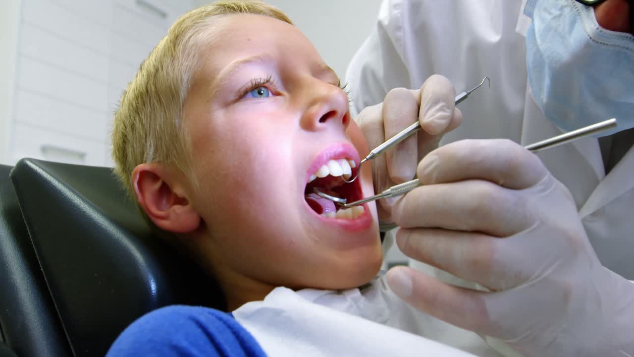 dentista examinando a un paciente joven con herramientas
