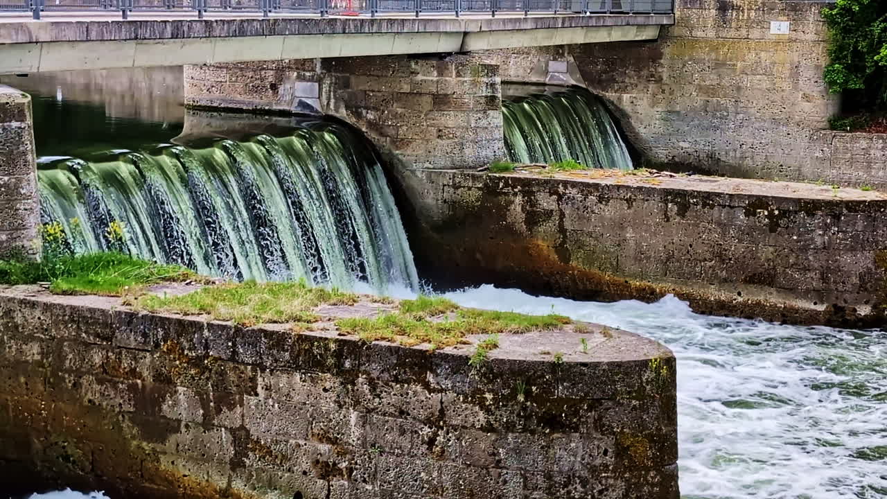 Flowing water over stones and moss in Ludwigswehr on the Isar rivers, natural peaceful scene, slow motion