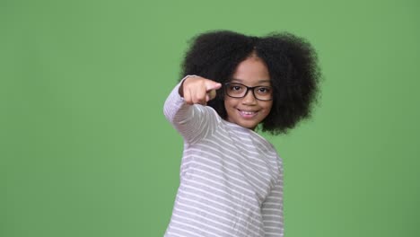 young cute african girl with afro hair pointing at camera