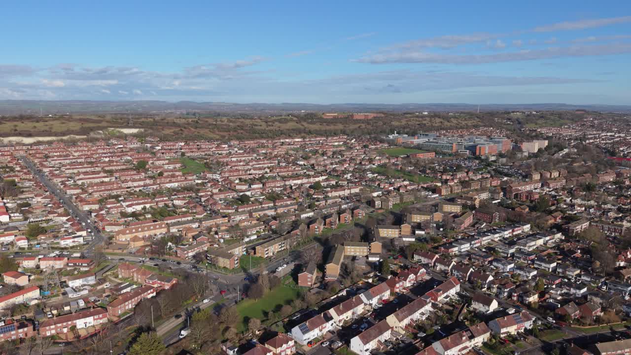 Das Queen Alexandra Hospital Portsmouth veröffentlicht Drohnenaufnahmen des Krankenhauses und der umliegenden Wohnbebauung bei strahlendem Sonnenschein an einem klaren Tag, mit Blick auf die Hügel und die dahinterliegende Landschaft.