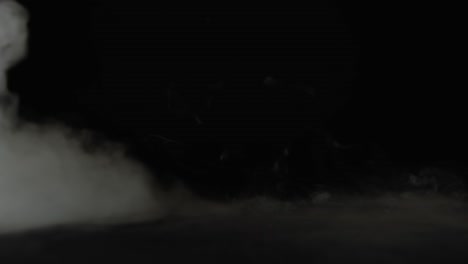 terrible mummy hand rising out from the smoke at black background. slow motion