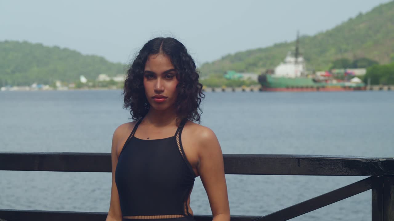 On a sunny day, a girl in a bikini explores the boardwalk and sandy shores of a Caribbean island.