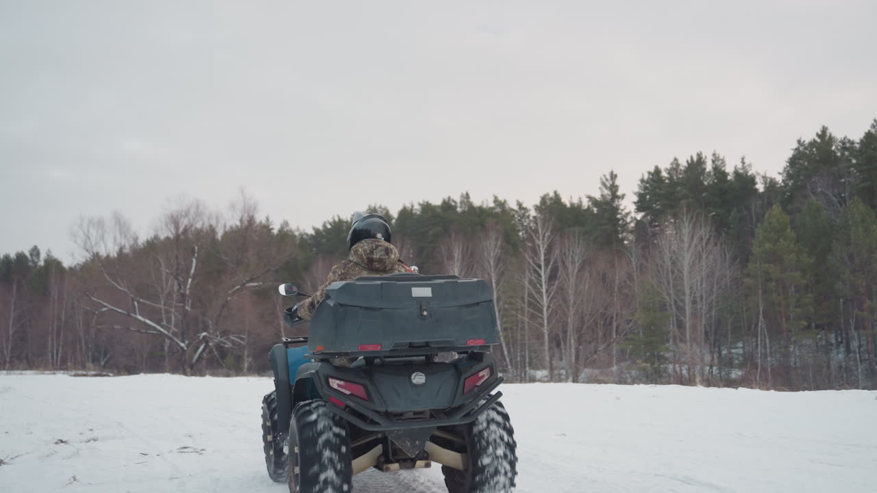 Preparazione per un'avventura invernale sulla neve. Il pilota off-road si equipaggia per avventure di spedizione in una foresta ghiacciata. L'operatore dell'ATV pianifica meticolosamente e si prepara per un impegnativo viaggio nel bosco invernale.