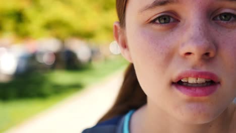 Extreme-close-up-of-fifteen-year-old-girl-who-looks-over-her-shoulder-and-then-back-at-camera