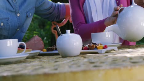 woman pouring tea in cup