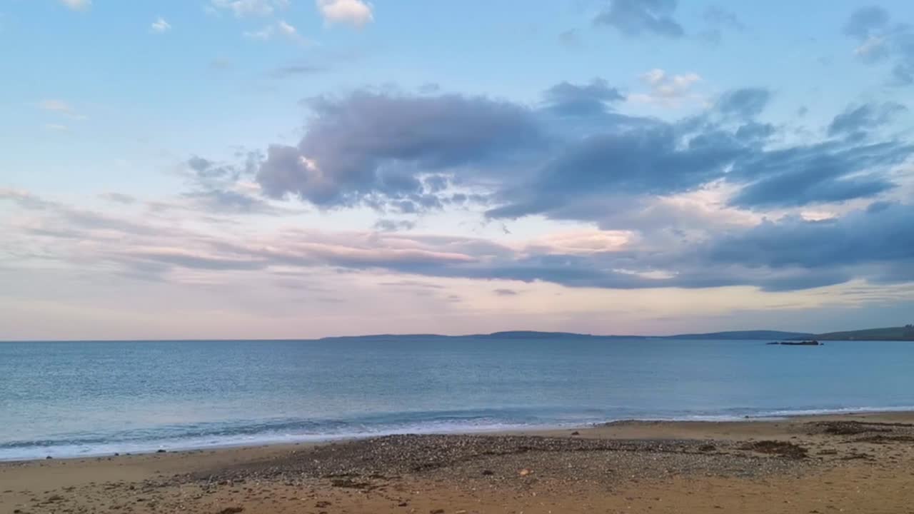 Handheld footage of a public beach in Ireland with warning sign for Coronavirus on a cloudy morning