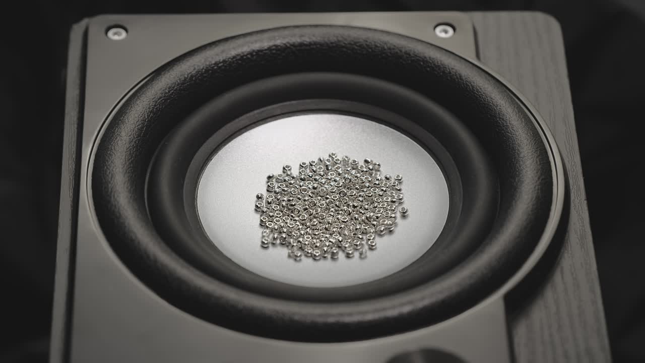 떨리는 스피커가 금 입자를 던집니다. 녹음 스튜디오에서 바스 사운드. 파티 또는 콘서트 영상. 바스 큰 스피커는 공중에 먼지를 습니다. 슈퍼 슬로 모션. 이라이저 개념.