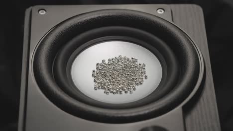 un altavoz tembloroso lanza una partícula de oro de cuentas. sonido de bajo en un estudio de grabación. imágenes de fiestas o conciertos. altavoz de bajo arroja polvo en el aire. movimiento súper lento. concepto de ecualizador.
