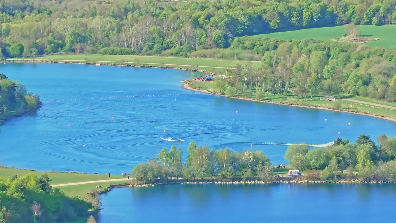 Aerial: jet skis on the lake during the day in Rother Valley Country Park in the Metropolitan Borough of Rotherham, South Yorkshire, England, establishing drone shot