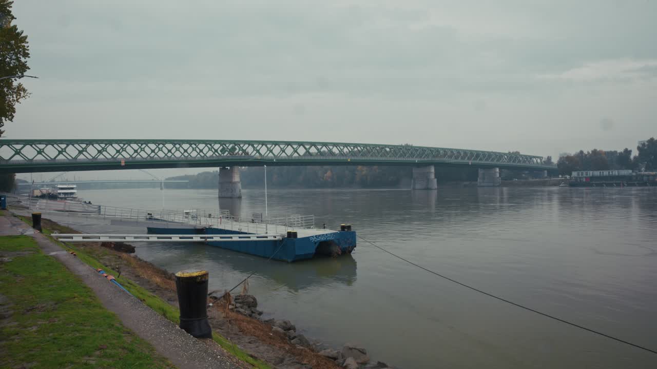 Steel truss bridge spanning the Danube River in Bratislava under cloudy skies