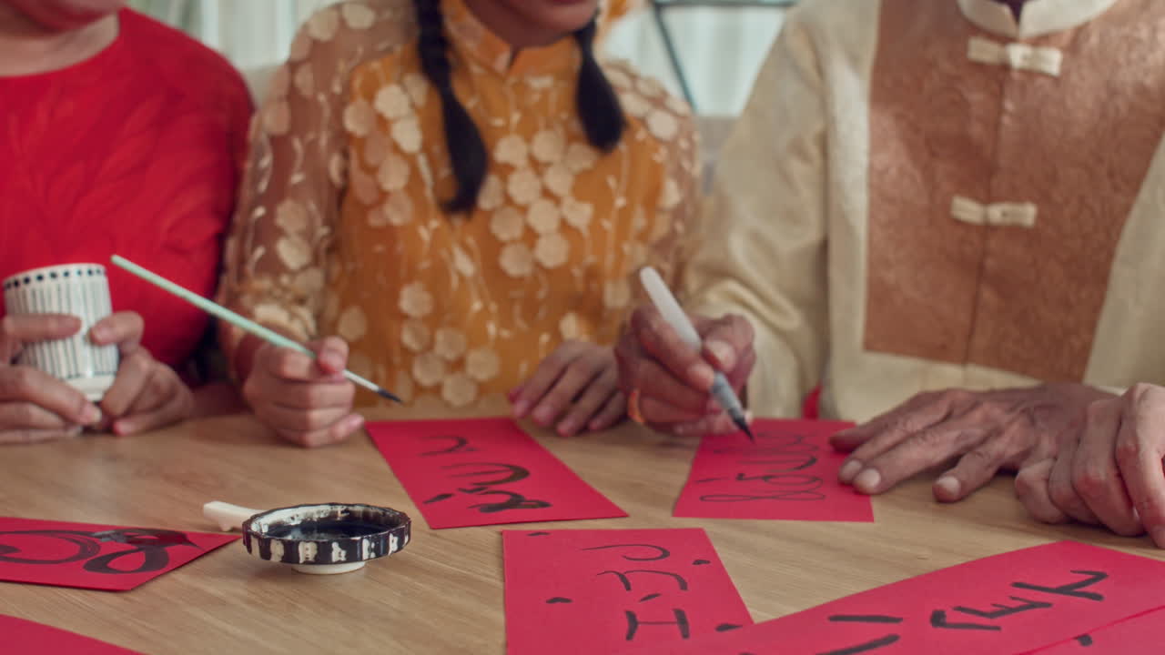 Granddaughter Writing Calligraphy on Red Paper with Grandparents