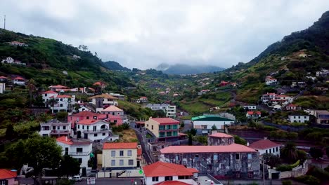 aerial shot over houses towards hill porto da cruz, madeira, portugal