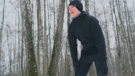 Ein-Junger-Mann,-Der-Morgens-Im-Winterwald-Joggte,-War-Müde-Und-Blieb-Stehen,-Um-Zu-Atem-Zu-Kommen.-Er-Kam-Wieder-Zu-Kräften,-überwand-Die-Müdigkeit-Und-Lief-Weiter.-Ausdauer-Und-Überwindung-Von-Schwächen.-Vorstoßen