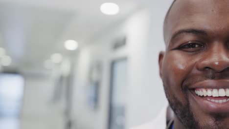 Portrait-of-happy-african-american-male-doctor-in-hospital-in-slow-motion