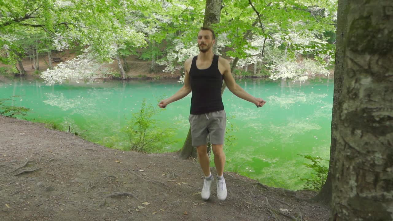 hombre deportivo saltando la cuerda en la naturaleza.