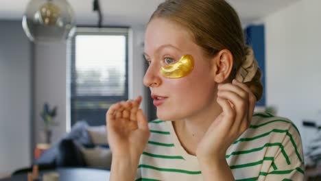 woman applying gold eye patches