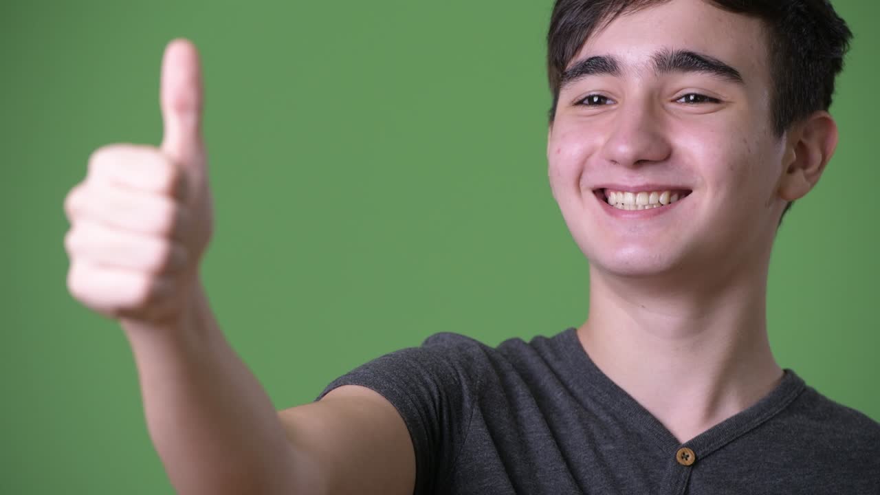 초록색 배경에 젊은 잘생긴 이란 십대 소년