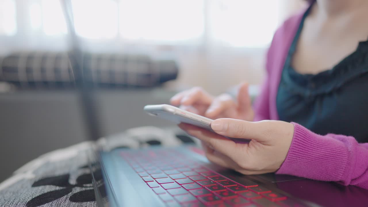 una mujer en primer plano sentada en un sofá sosteniendo un teléfono inteligente para comprar en línea en casa