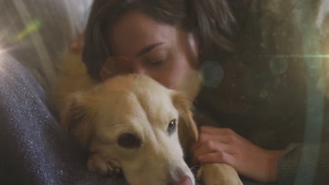 spot of light against close up of caucasian woman hugging her dog at home