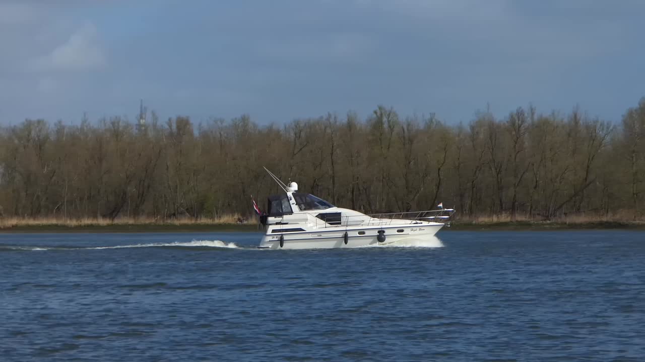 Luxury motor yacht sails on the river. View from the side. Slow motion, 50fps