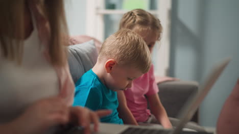 Los-Niños-Pequeños-Juegan-Sentados-Cerca-De-La-Madre-Trabajando-En-La-Computadora-Portátil.