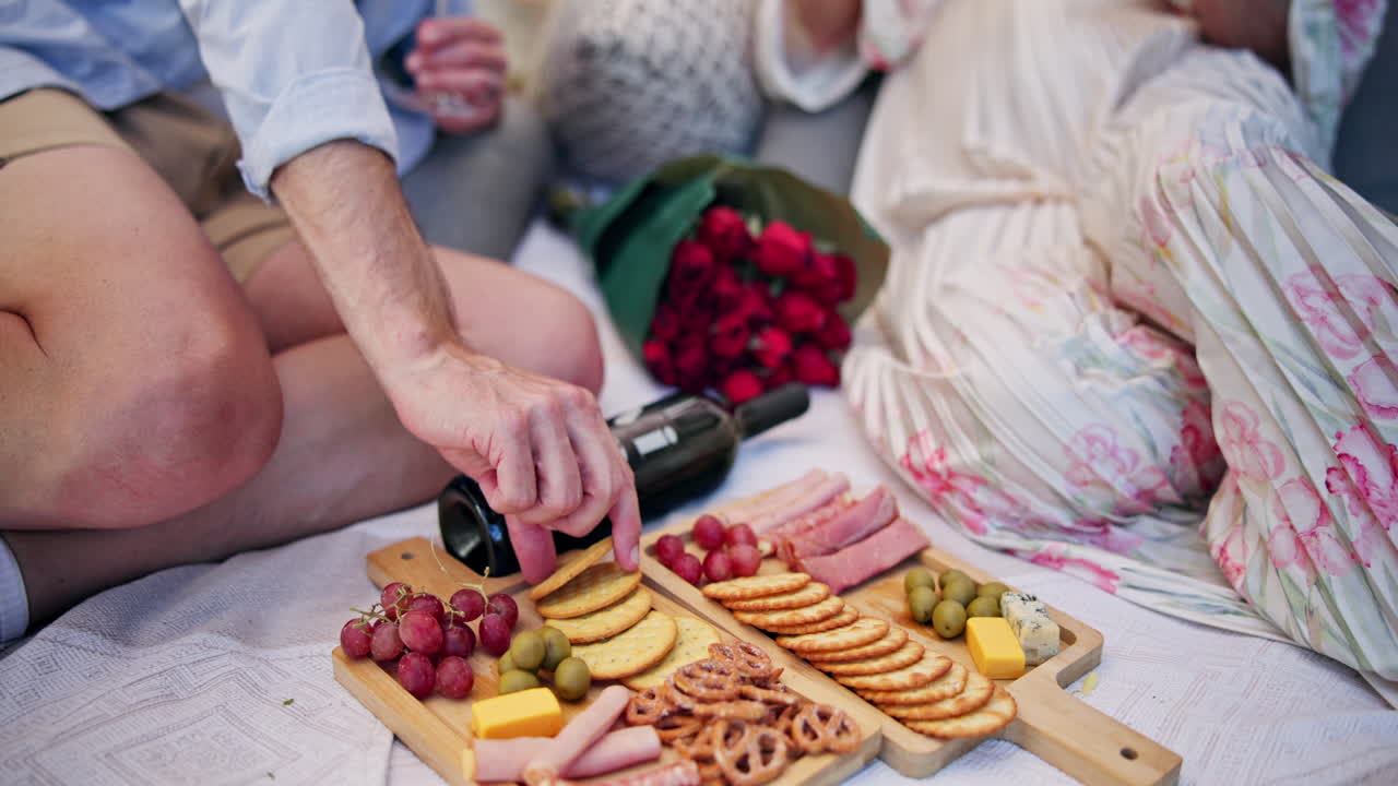 Pareja disfrutando de un pícnic romántico con embutidos y vino