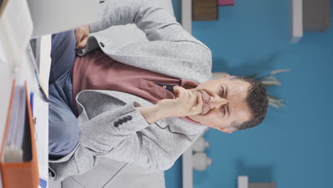 vertical video of home office worker old man thinking looking at camera.