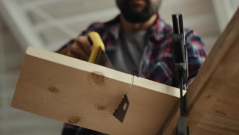 video of woodworker cutting block of wood using hand saw