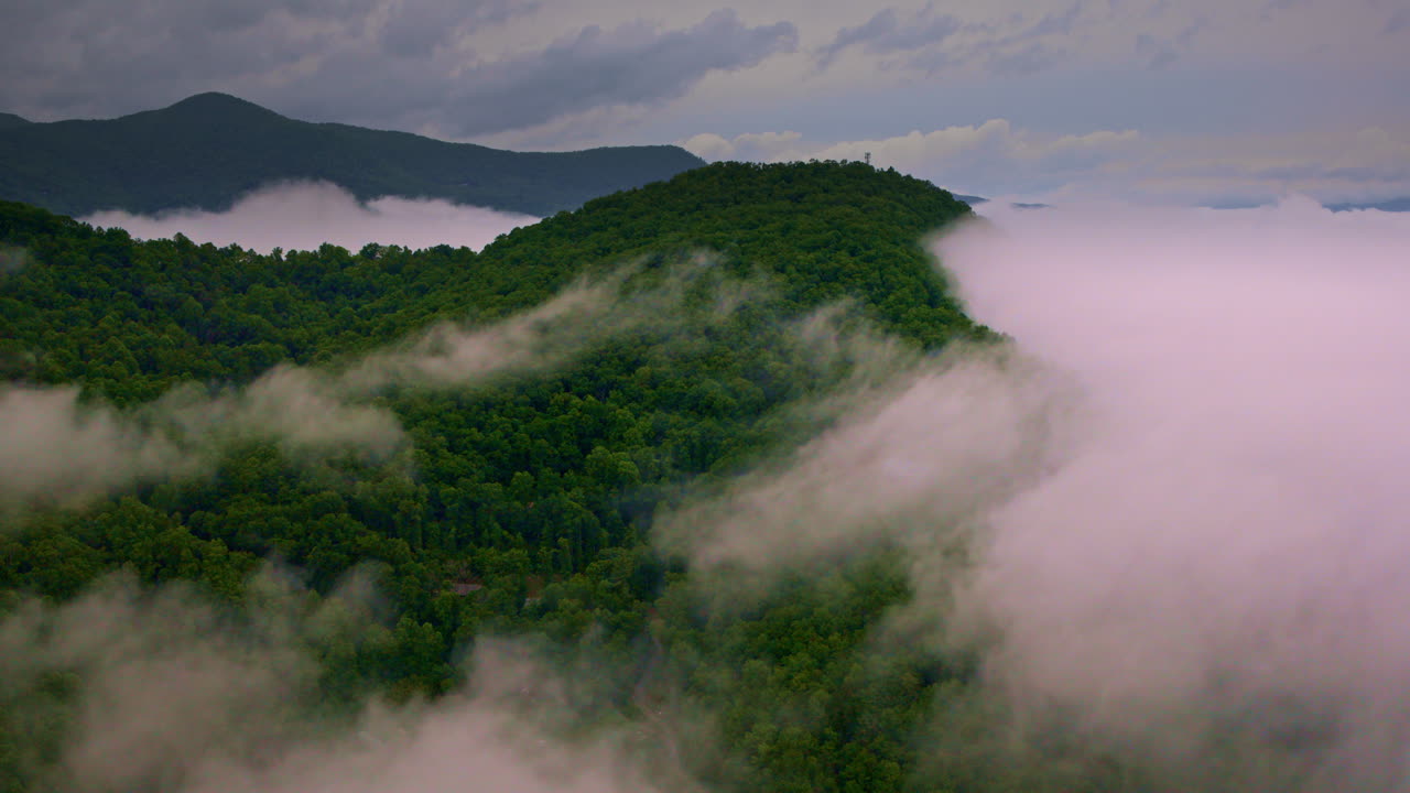 Drone shot of smoky mountains with fog running into the land