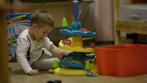 Little-boy-playing-with-a-plastic-parking-garage