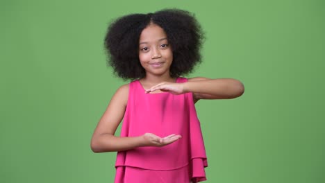 young cute african girl with afro hair showing something