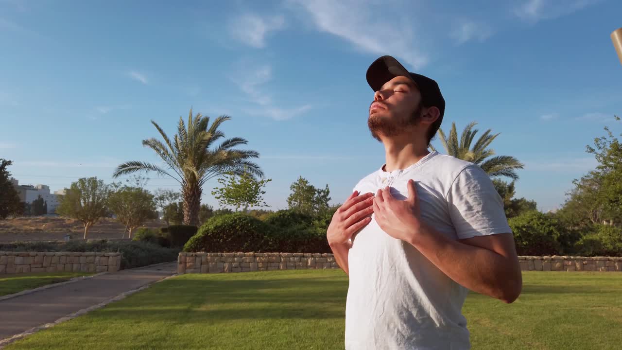 Side view portrait of a happy young men breathing fresh air in the public park.