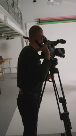 video vertical del operador de cámara de película director de rodaje hablando con actores masculinos y femeninos sosteniendo guiones ensayando para rodar una película o video en el estudio