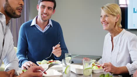 hombres de negocios interactuando mientras desayunan