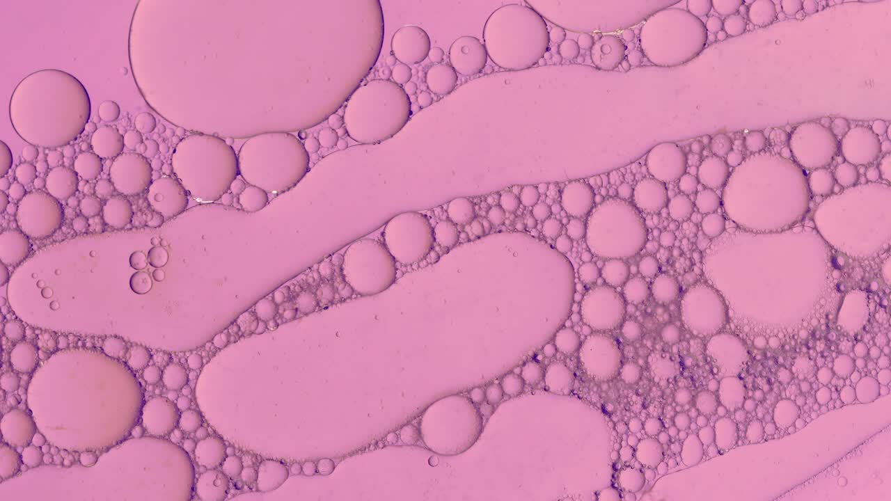 Fondo abstracto de gotas de aceite en líquido rosa claro para tratamientos cosméticos Hidrogel