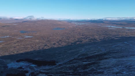 Paisaje-Escarpado-De-Glencoe-Con-Lagos-Dispersos-Bajo-Un-Cielo-Azul,-Vista-Aérea