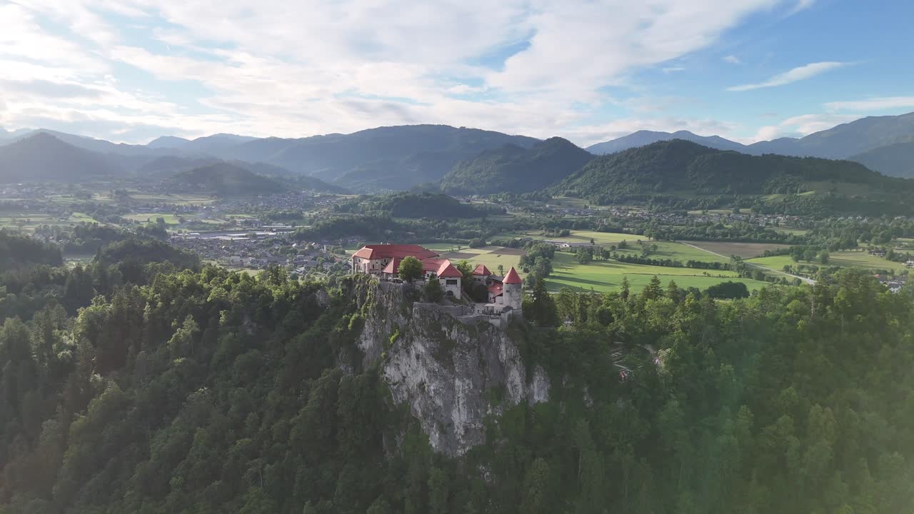 Bled Kalesi ve Güneş, Sinematik Parıltılarla, Havadan, Geniş Dairesel Drone Çekimi