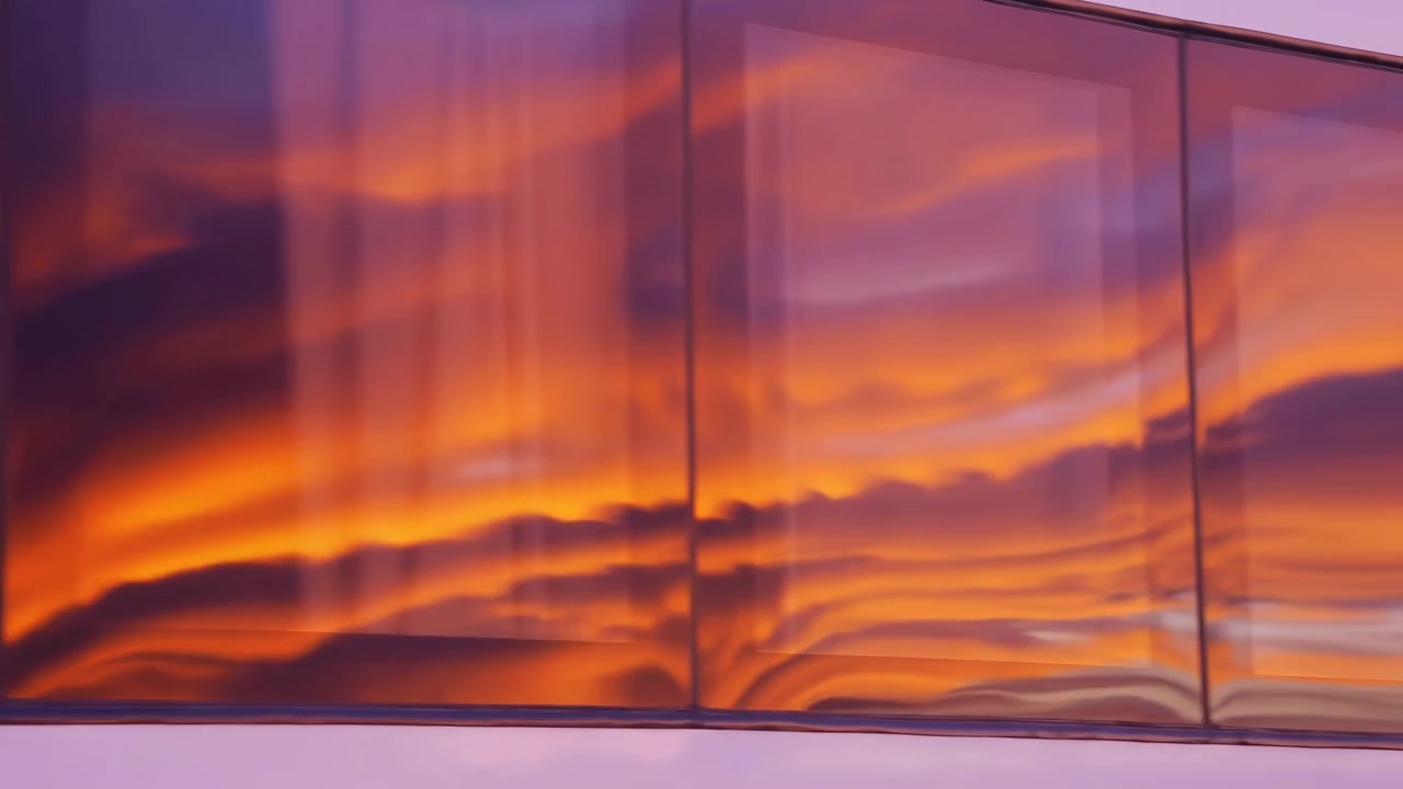 Exterior glass facade or balcony railing shows vivid sunset sky mirrored across multiple vertical panes as cloud bands move in alignment and brightness, creating warm urban color and soft abstract