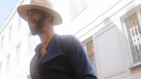 happy afro caribbean man with panama hat dancing latin dance alone in the old town street 4