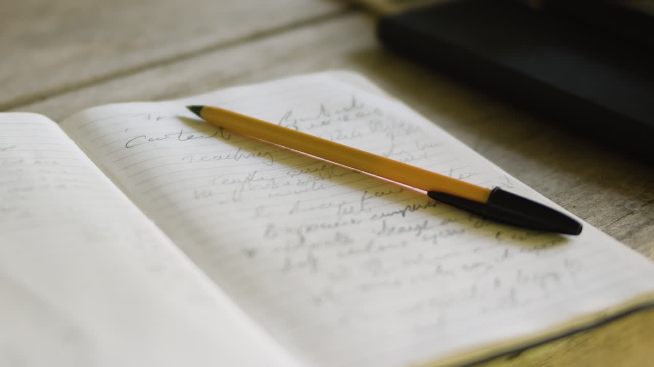 Close up pen on paper with small illegible handwriting notes in diary