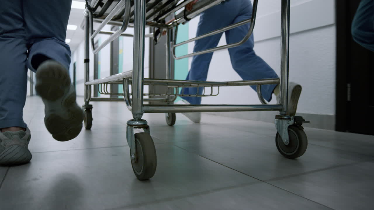 의사들의 발이 병원 복도를 따라 달리고 의료팀이 기차를 옮기고 있습니다.