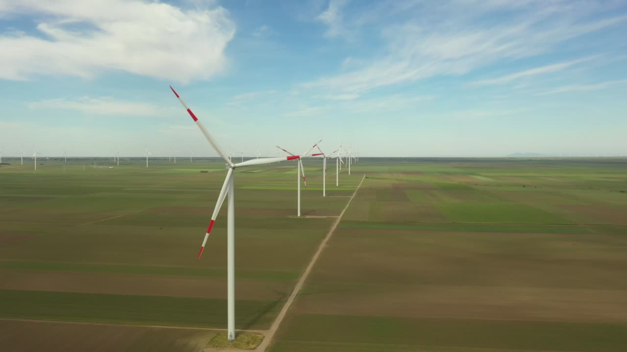 вид на несколько ветряных мельниц, ветряных генераторов, турбин, производящих возобновляемую чистую энергию путем преобразования кинетической энергии