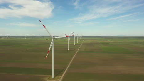 view on several windmills, wind generators, turbines, producing renewable clean energy by converting kinetic energy