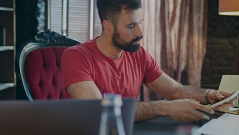 Business-man-working-on-laptop-and-chatting-on-phone-in-office