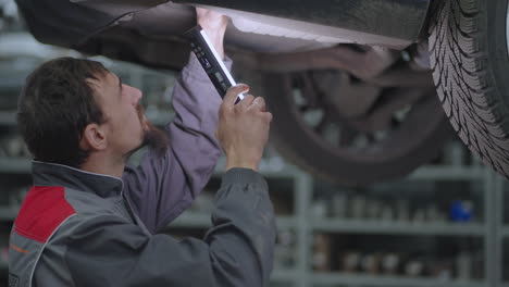 a man foreman inspects the exhaust system of a car