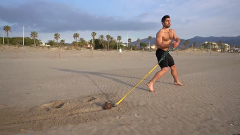 Hacer-Ejercicio-En-La-Playa-Con-Zancada-Larga-Ofreciendo-Resistencia-Con-Peso